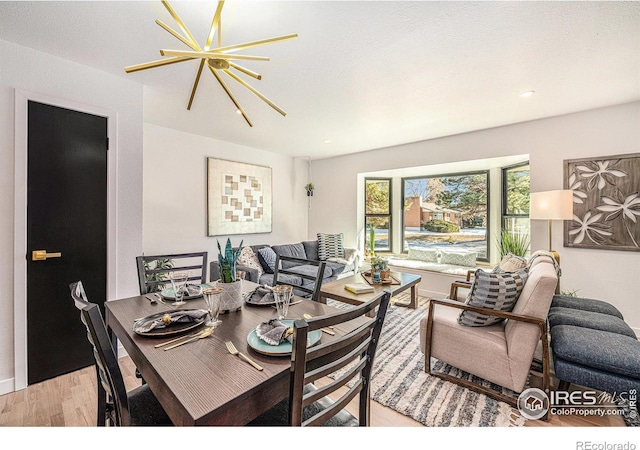 dining space with a notable chandelier and light wood-type flooring