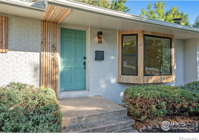 property entrance featuring brick siding