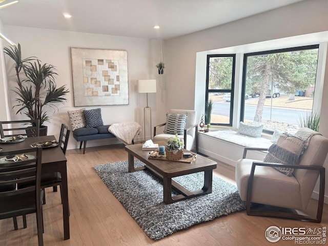 living area with recessed lighting, baseboards, and wood finished floors