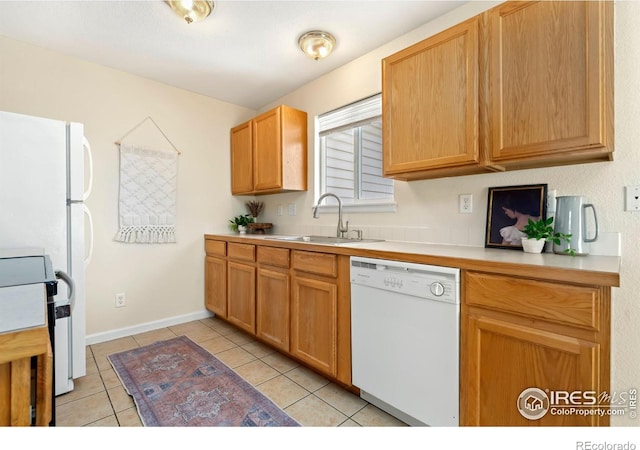 kitchen featuring white dishwasher, sink, electric range oven, and light tile patterned flooring