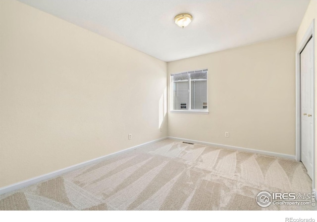 unfurnished bedroom with a closet and light carpet