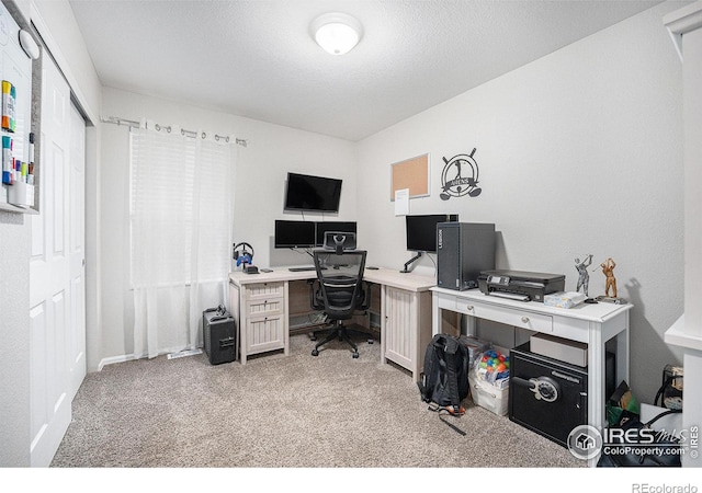 carpeted office featuring a textured ceiling