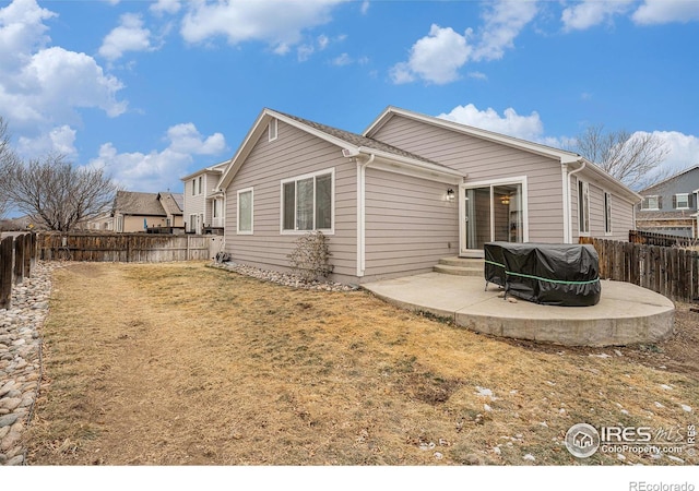 back of house with a lawn and a patio area