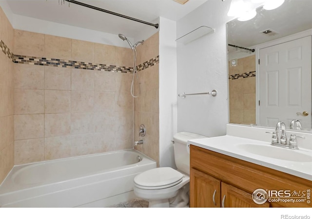 full bathroom featuring vanity, tiled shower / bath combo, and toilet