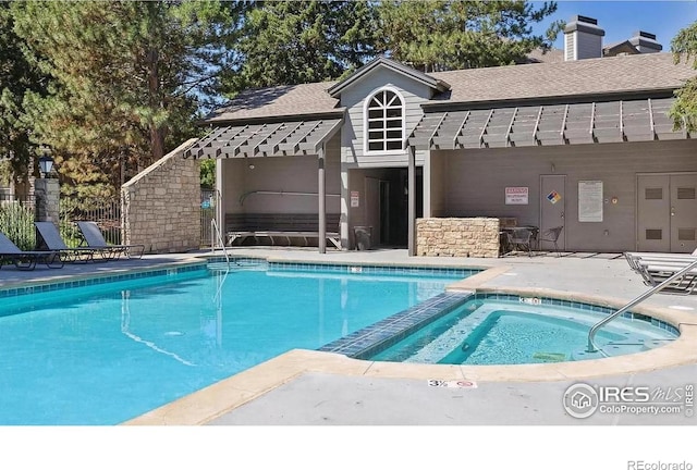 view of pool with a hot tub and a patio area