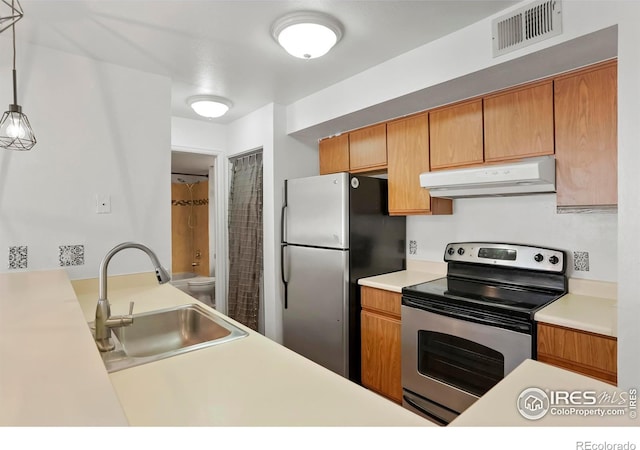 kitchen featuring appliances with stainless steel finishes, sink, and pendant lighting