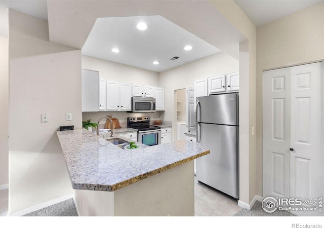 kitchen with sink, kitchen peninsula, white cabinets, and appliances with stainless steel finishes