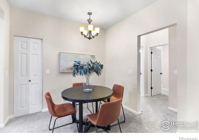 dining space featuring light carpet and a notable chandelier