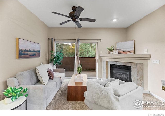 carpeted living room with ceiling fan and a high end fireplace