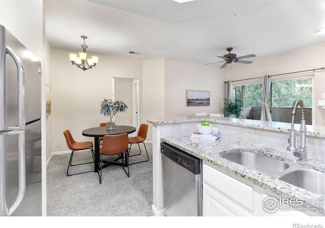 kitchen with light colored carpet, stainless steel appliances, sink, and white cabinets