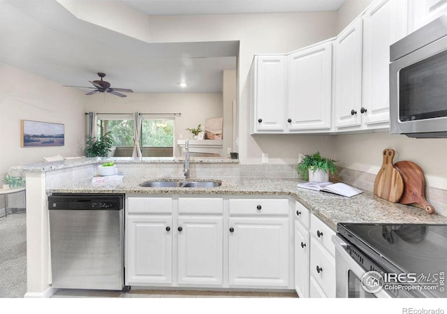 kitchen featuring sink, kitchen peninsula, white cabinets, and appliances with stainless steel finishes