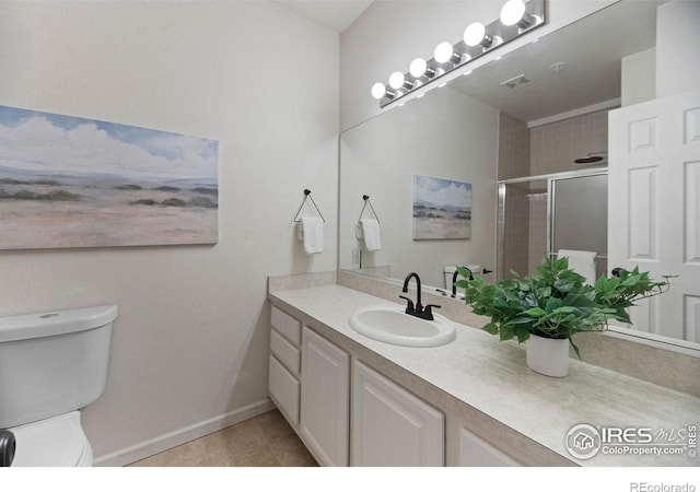 bathroom featuring vanity, tile patterned floors, a shower with door, and toilet