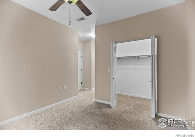 unfurnished bedroom featuring ceiling fan, a closet, and light carpet