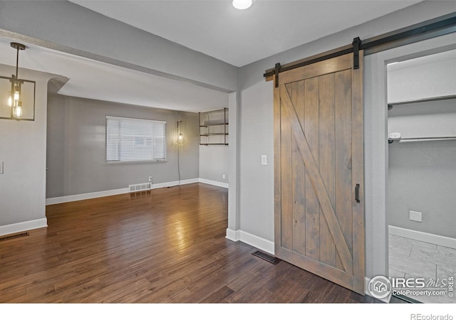 interior space featuring dark hardwood / wood-style flooring and a barn door