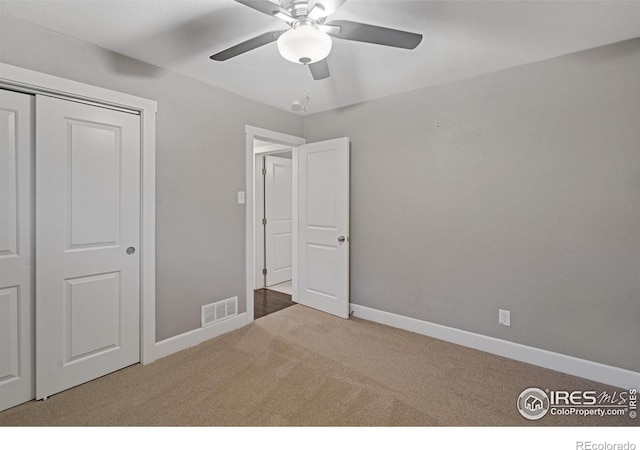 unfurnished bedroom featuring carpet floors, a closet, and ceiling fan