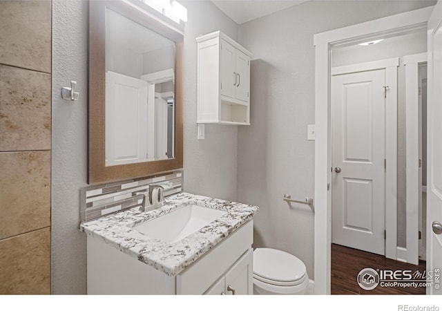 bathroom with vanity, wood-type flooring, and toilet