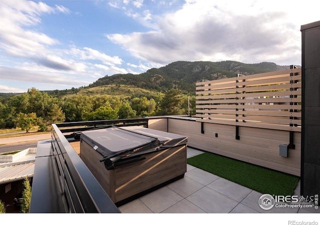 view of patio / terrace with a mountain view and a hot tub