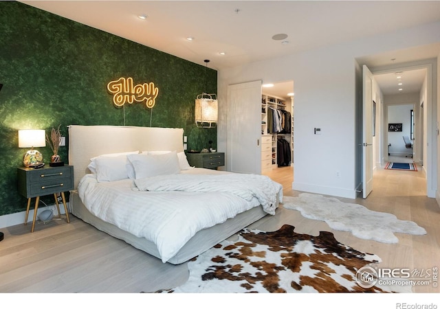 bedroom featuring a spacious closet, hardwood / wood-style floors, and a closet