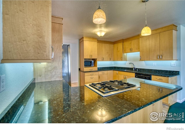 kitchen featuring sink, hanging light fixtures, light brown cabinets, dark stone countertops, and black appliances