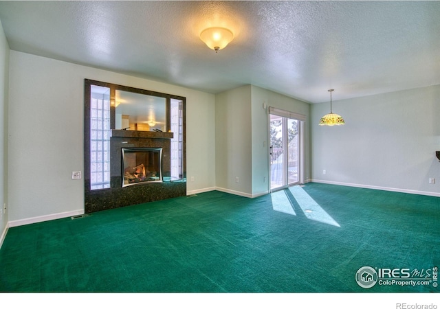 unfurnished living room with dark carpet and a textured ceiling