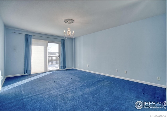 carpeted spare room with a notable chandelier