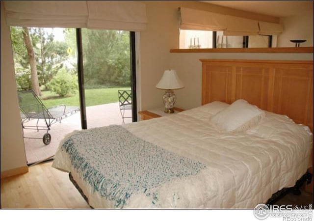 bedroom featuring light hardwood / wood-style flooring, multiple windows, and access to outside