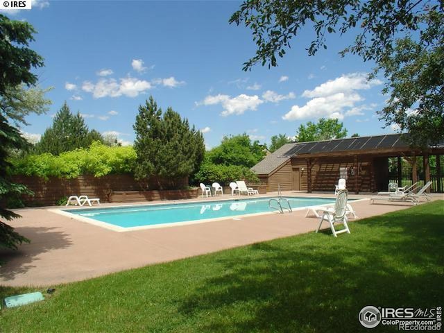 view of pool with a yard and a patio area