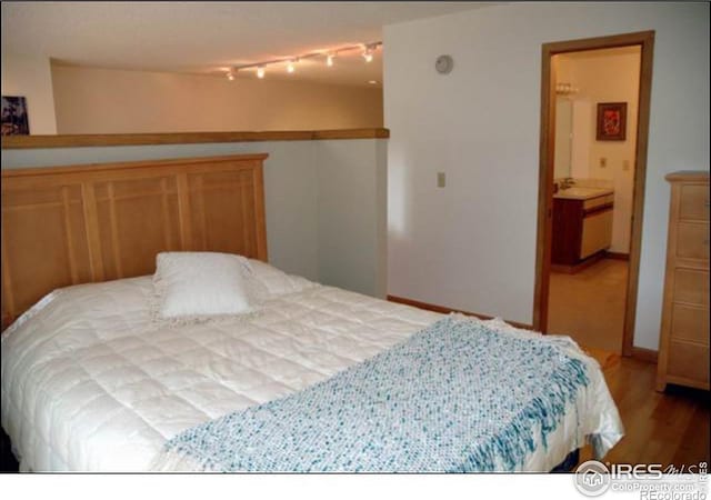 bedroom featuring wood-type flooring and ensuite bathroom