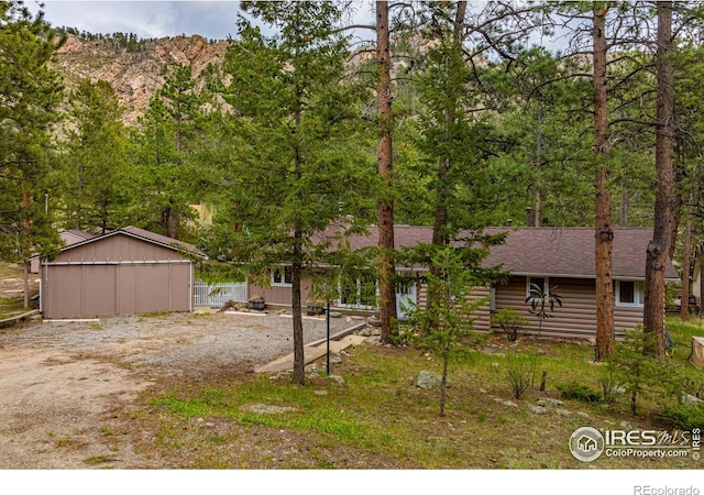 view of front of home with a mountain view and an outdoor structure