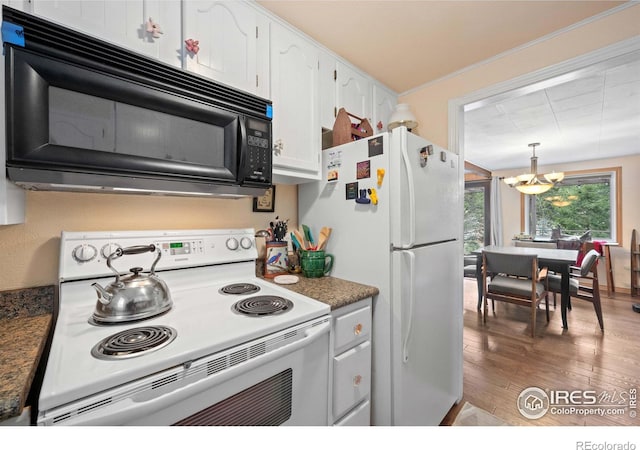 kitchen with white appliances, hardwood / wood-style flooring, a notable chandelier, white cabinets, and decorative light fixtures