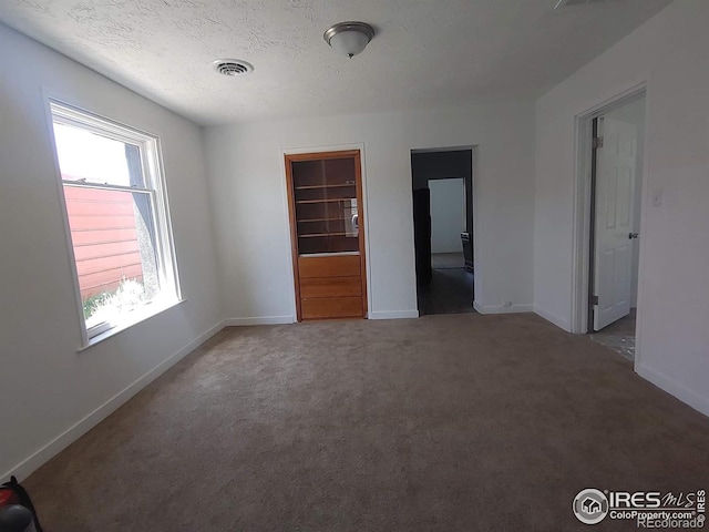 carpeted spare room with a textured ceiling