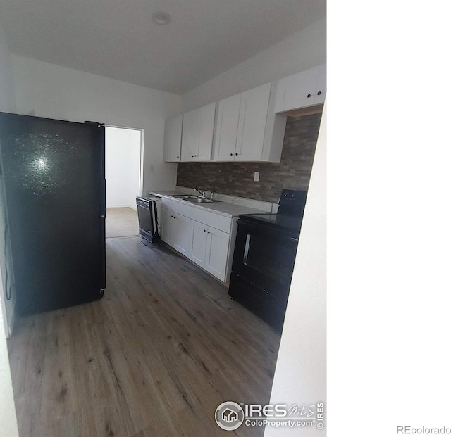 kitchen with sink, tasteful backsplash, black appliances, dark hardwood / wood-style flooring, and white cabinets