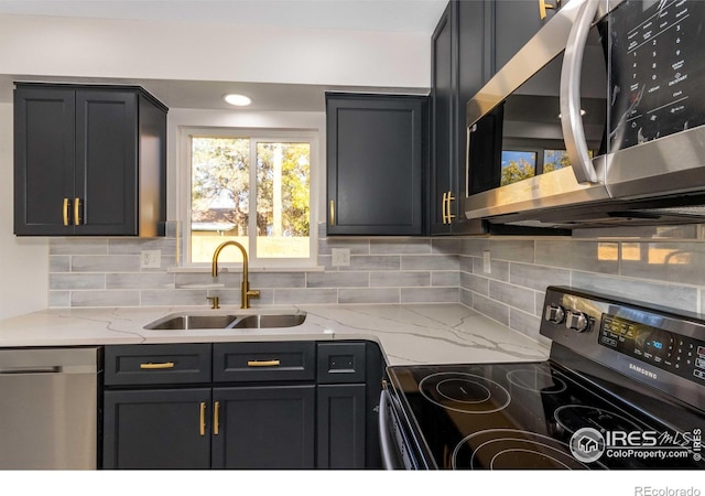 kitchen featuring sink, backsplash, light stone countertops, and appliances with stainless steel finishes