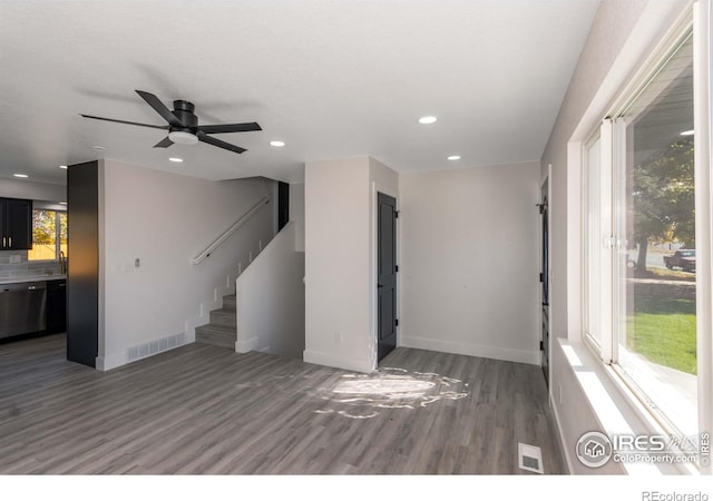 unfurnished living room with dark hardwood / wood-style floors and ceiling fan