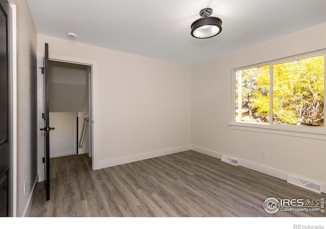 unfurnished room with dark hardwood / wood-style floors