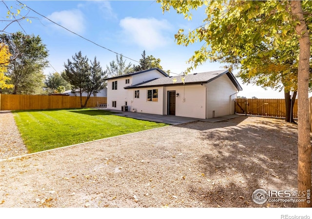 back of house with central AC unit, a patio area, and a lawn