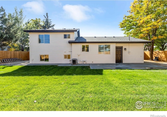 rear view of property with a patio area, central air condition unit, and a lawn