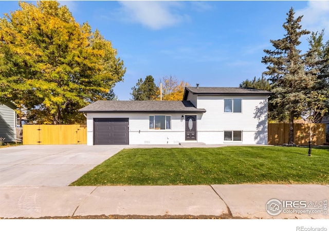 split level home featuring a garage and a front lawn