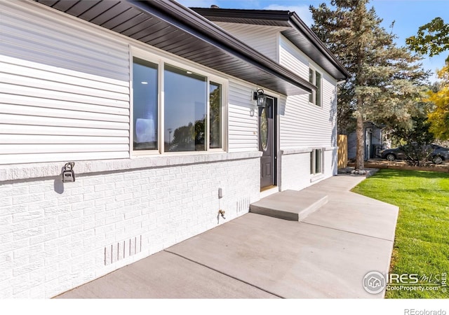 view of side of property featuring a yard and a patio area