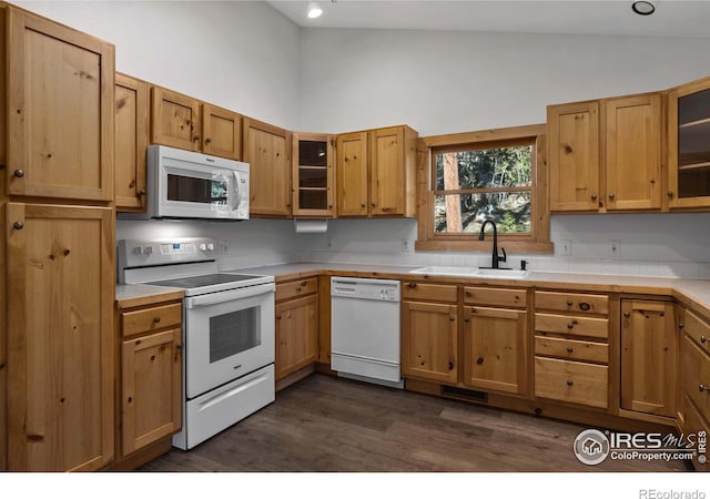 kitchen with lofted ceiling, sink, dark wood-type flooring, and white appliances