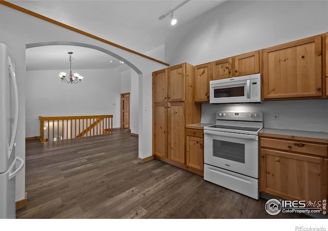 kitchen with rail lighting, dark hardwood / wood-style floors, a notable chandelier, pendant lighting, and white appliances