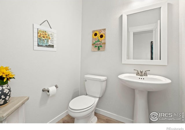 bathroom featuring hardwood / wood-style floors and toilet