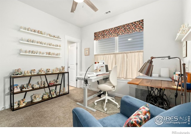 carpeted office space featuring ceiling fan