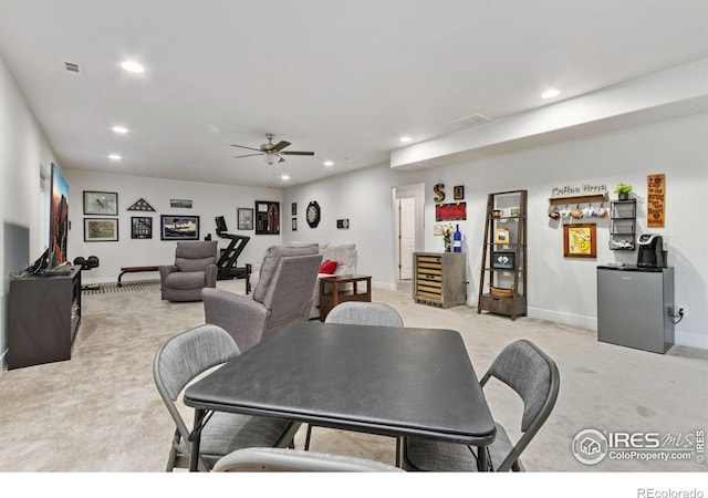 dining room with ceiling fan and light carpet