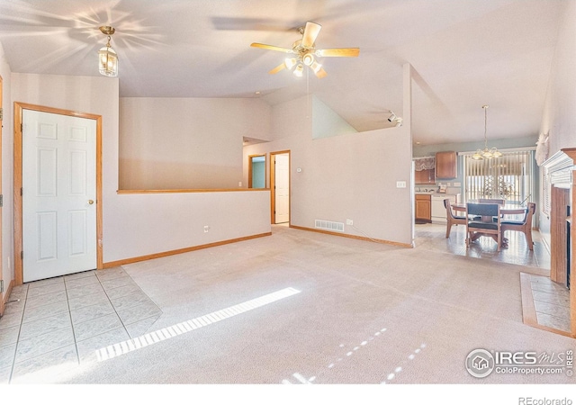 unfurnished room featuring ceiling fan with notable chandelier, lofted ceiling, and light carpet