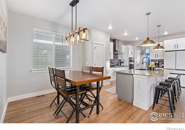 dining room featuring sink and light hardwood / wood-style flooring