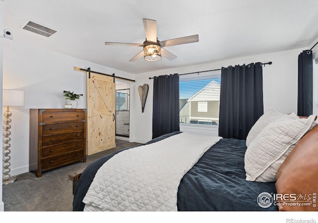 bedroom featuring ensuite bath, a barn door, ceiling fan, and carpet flooring