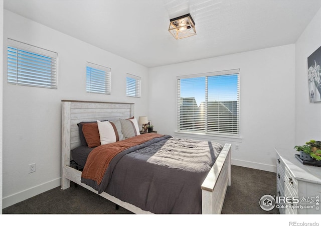 bedroom featuring multiple windows and dark colored carpet