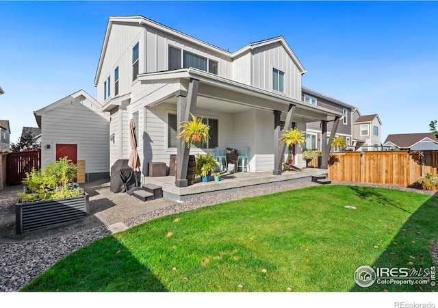 back of house featuring a patio area and a lawn