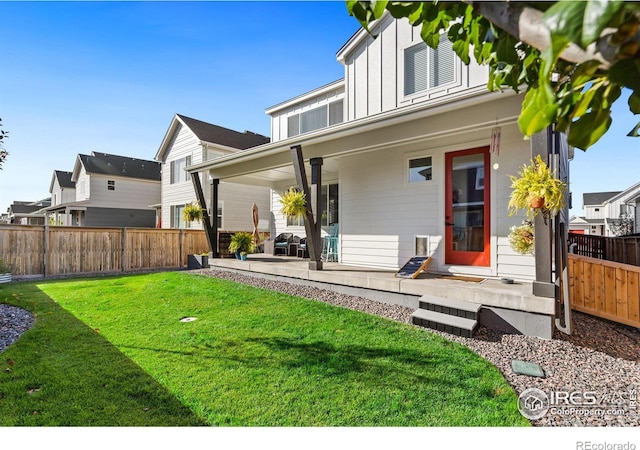 back of house with a patio area and a lawn